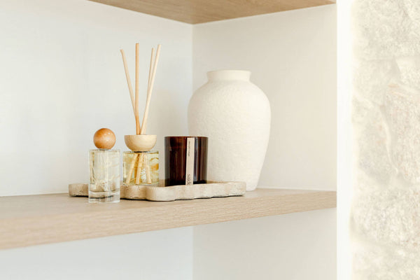 Decorative items on a wooden shelf against a white wall