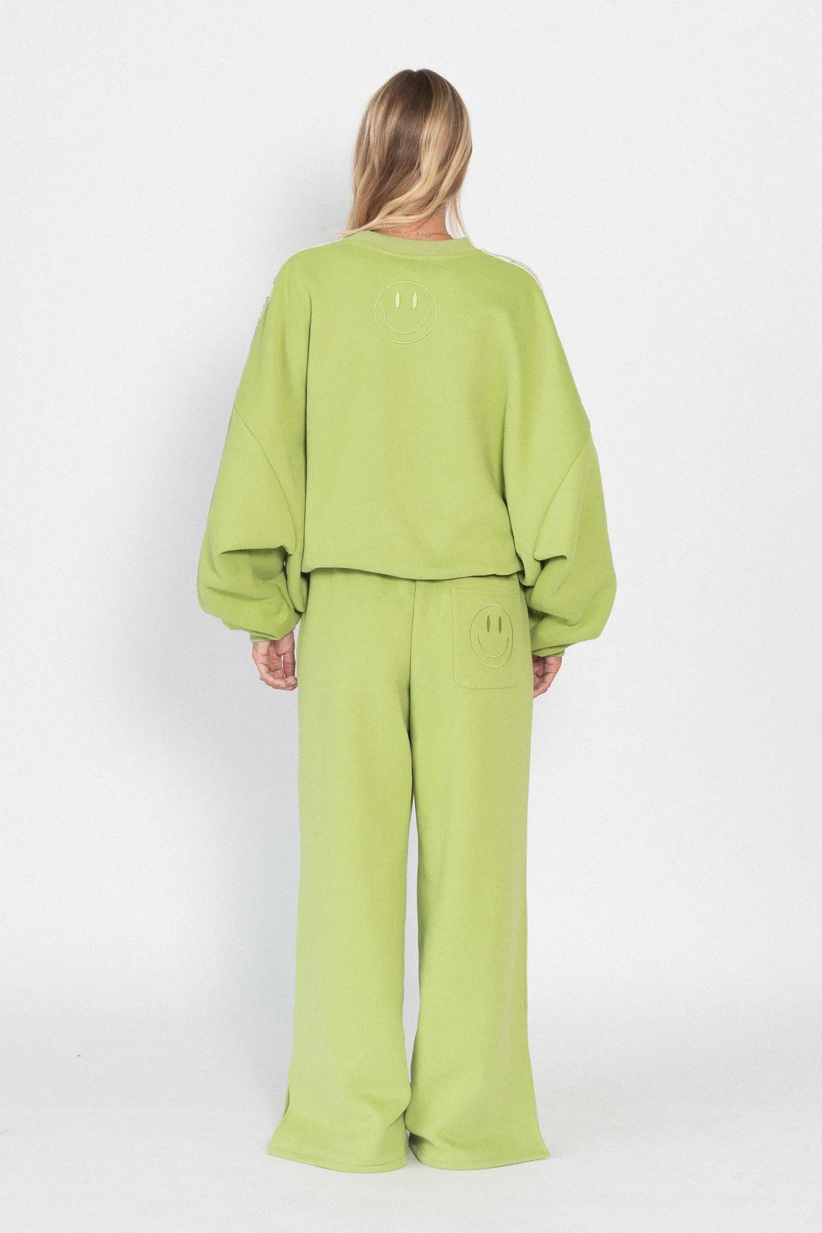 Person wearing a green outfit on a white background