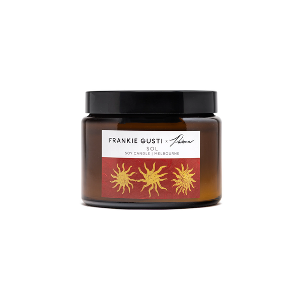 Candle jar with a label featuring sun designs on a white background