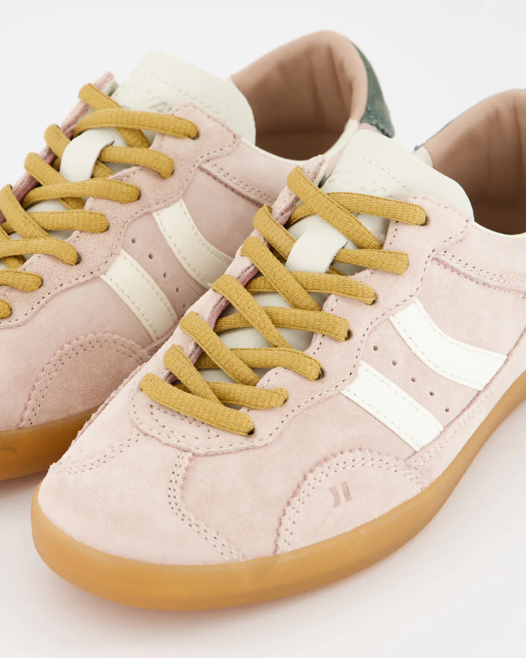 Pink sneakers with yellow laces on a light background