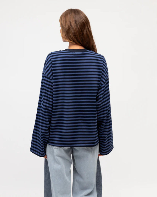 Person wearing a blue and black striped sweater on a white background