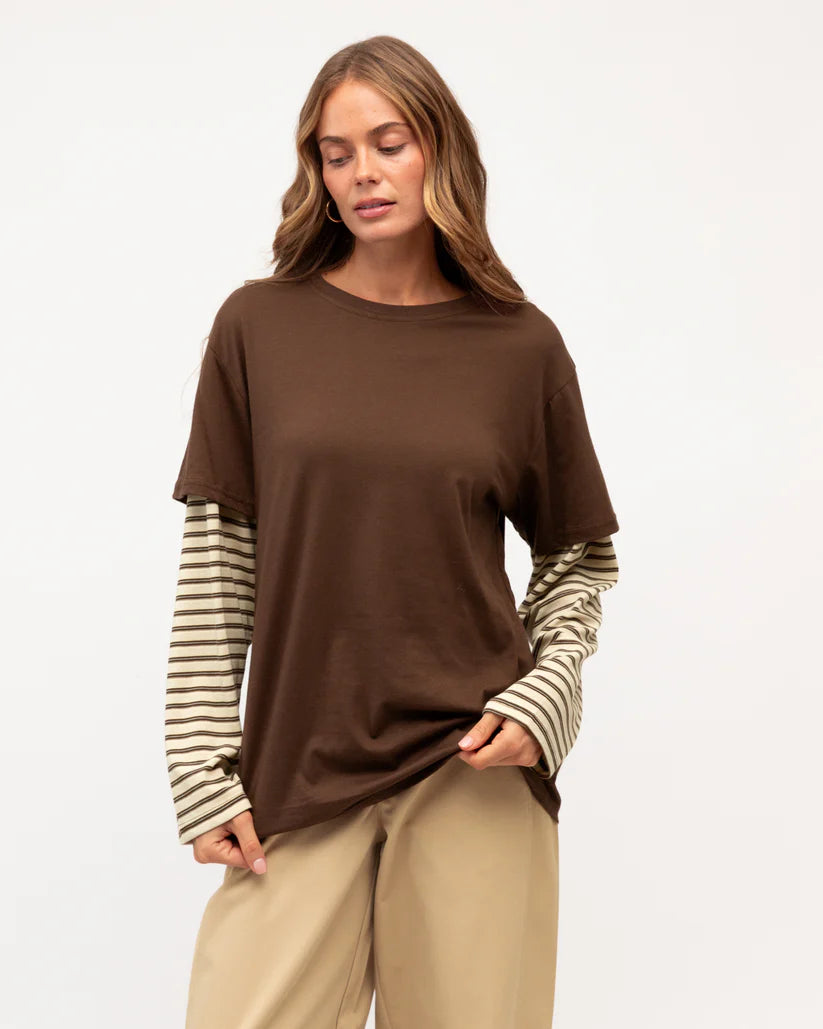 Woman wearing a brown t-shirt with striped sleeves on a white background