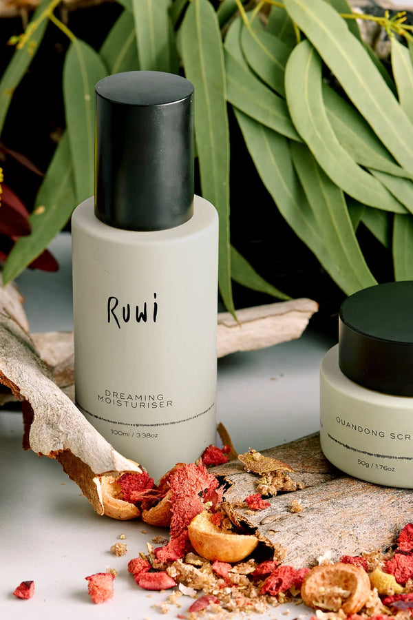 Skincare bottles with natural elements on a textured surface