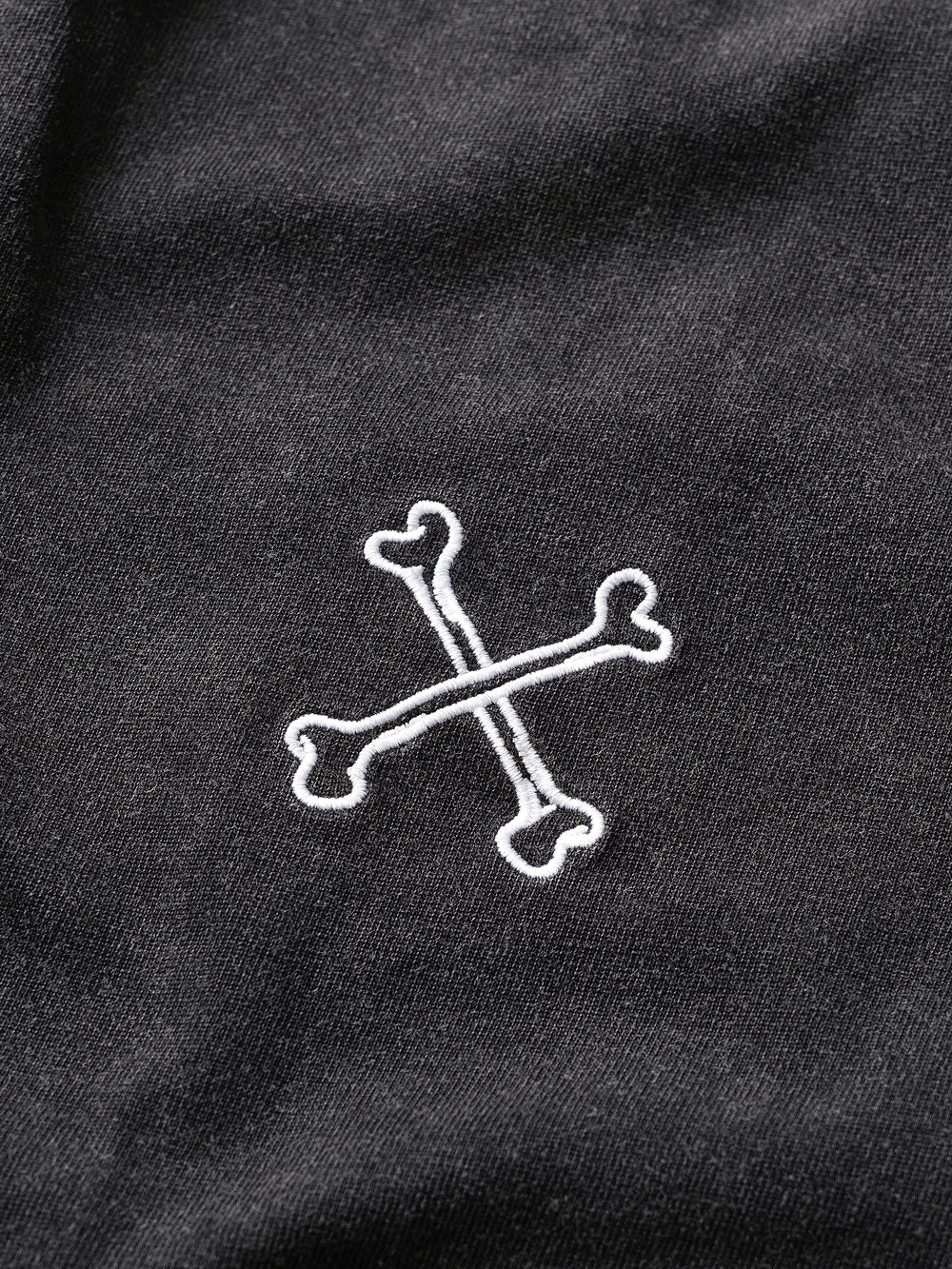 White skull and crossbones design on a black fabric background