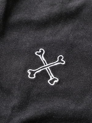 White skull and crossbones design on a black fabric background