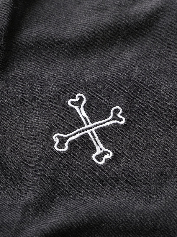 White skull and crossbones design on a black fabric background