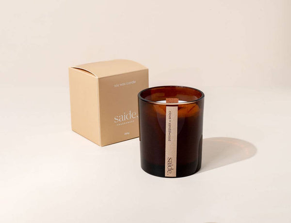 Brown candle with a visible brand name on a beige background