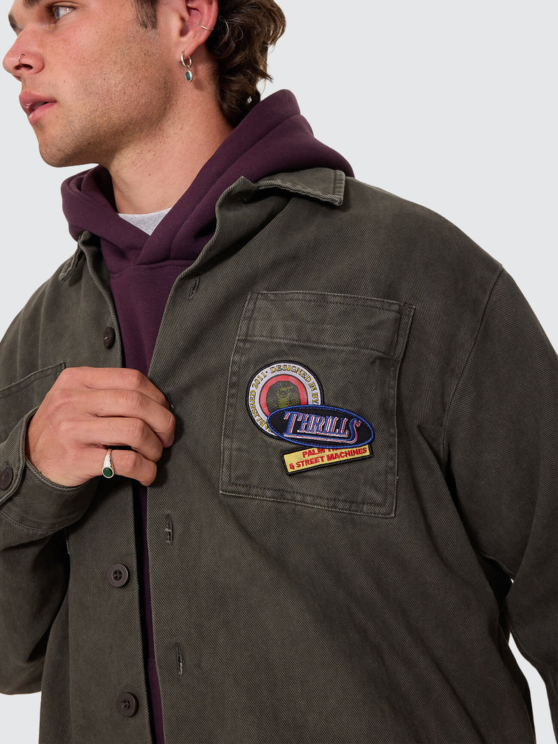 Man wearing a dark jacket with a brand logo on a white background