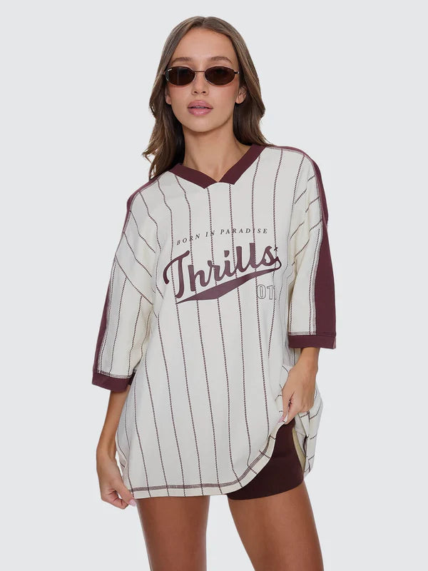 Woman wearing a maroon and white striped jersey with 'Thrills' branding on a white background