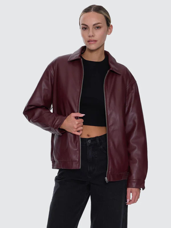 Person wearing a burgundy leather jacket on a white background